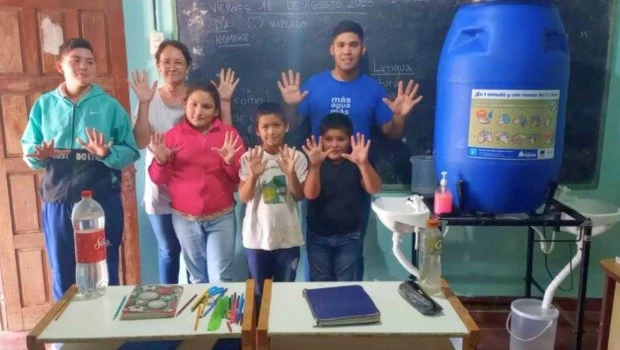 Los alumnos de la escuela rural Anexo Nº 888 junto a una estación de lavado de manos que representa una gran solución.