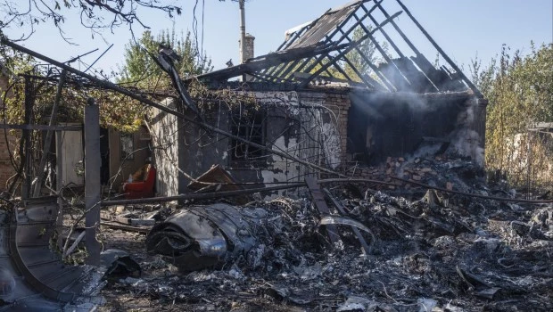 Una casa privada dañada se ve al fondo de los fragmentos de un avión militar ruso que fue derribado en las afueras de Kostyantynivka, una ciudad cercana a la línea del frente en la región de Donetsk, Ucrania (5 de octubre de 2024).