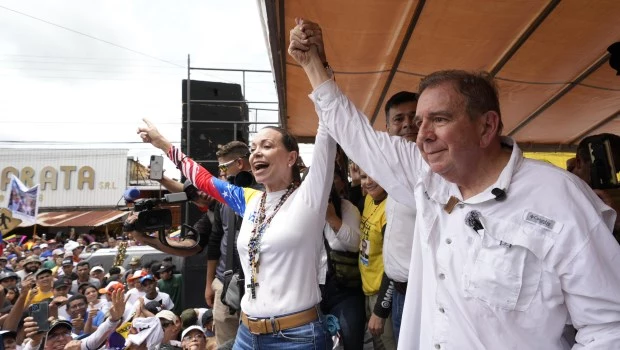 La líder opositora María Corina Machado ondea una bandera nacional de Venezuela en un acto de protesta.