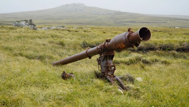 Un arma abadonada en las Malvinas con el fondo de Monte Longdon.